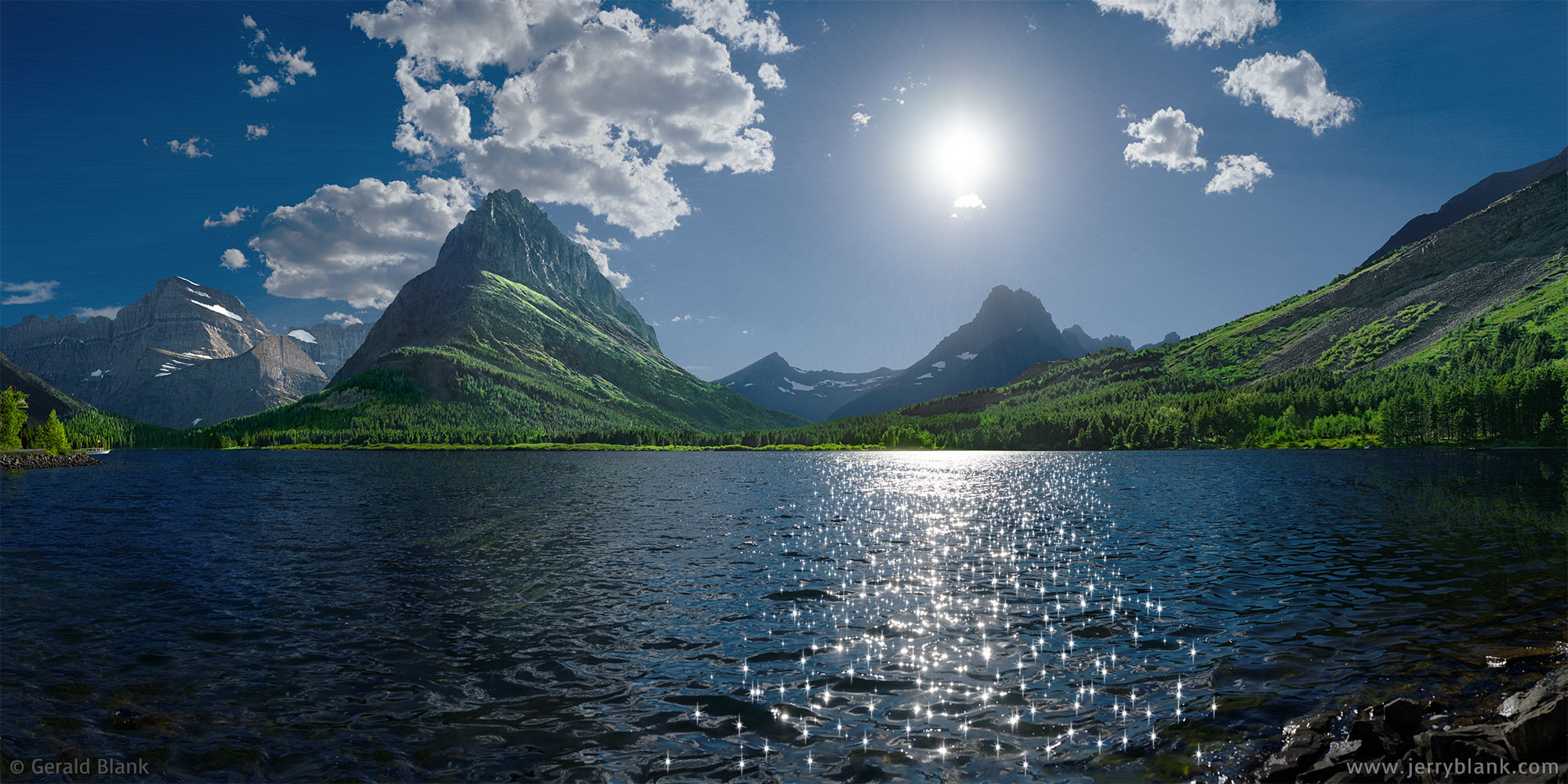 #67962 - The evening sun sparkles on Swiftcurrent Lake in Glacier National Park, Montana. Grinnell Point is seen at center-left, and Mount Wilbur is visible below the sun - photo by Jerry Blank