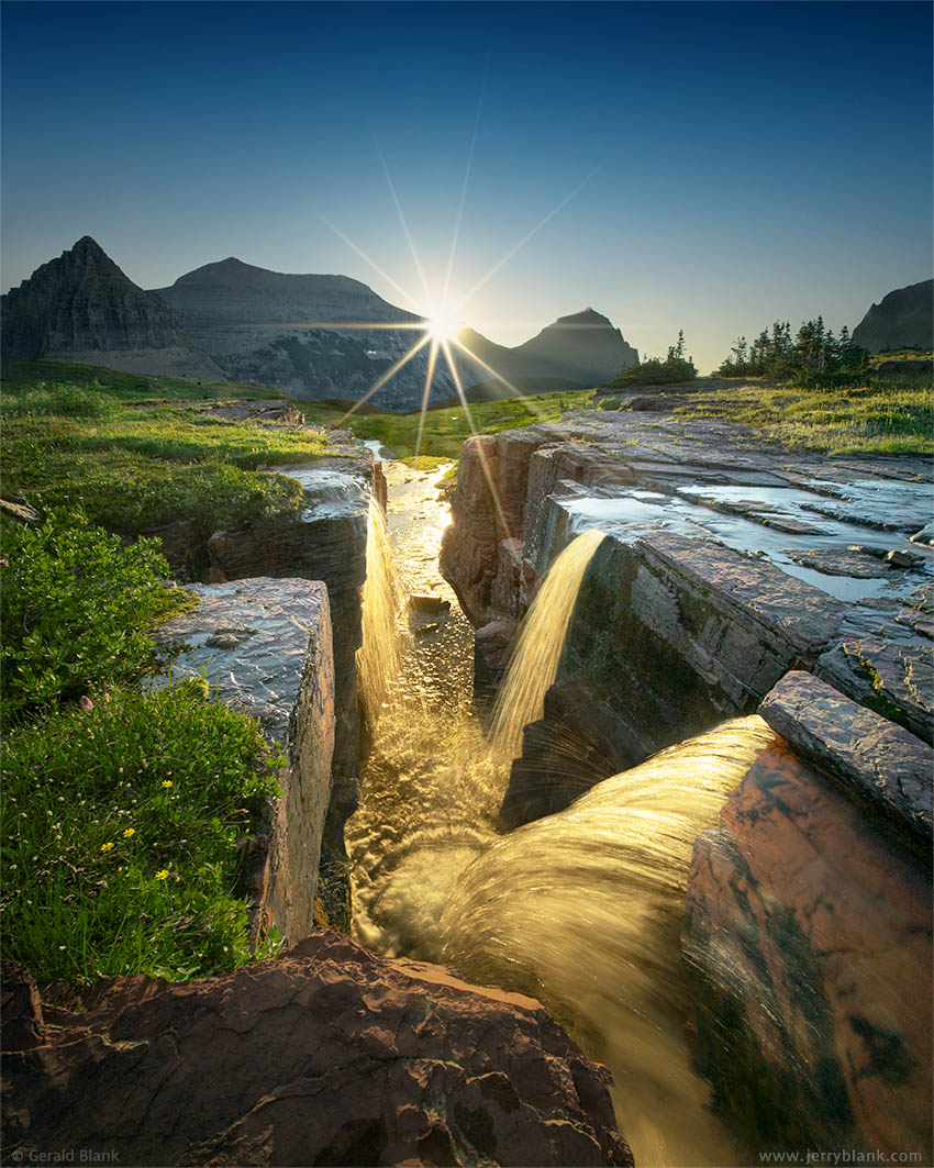 #67050 - The rays of the rising sun light up Triple Falls on Reynolds Creek, just east of the Continental Divide in the Hanging Gardens of Glacier National Park, Montana - photo by Jerry Blank